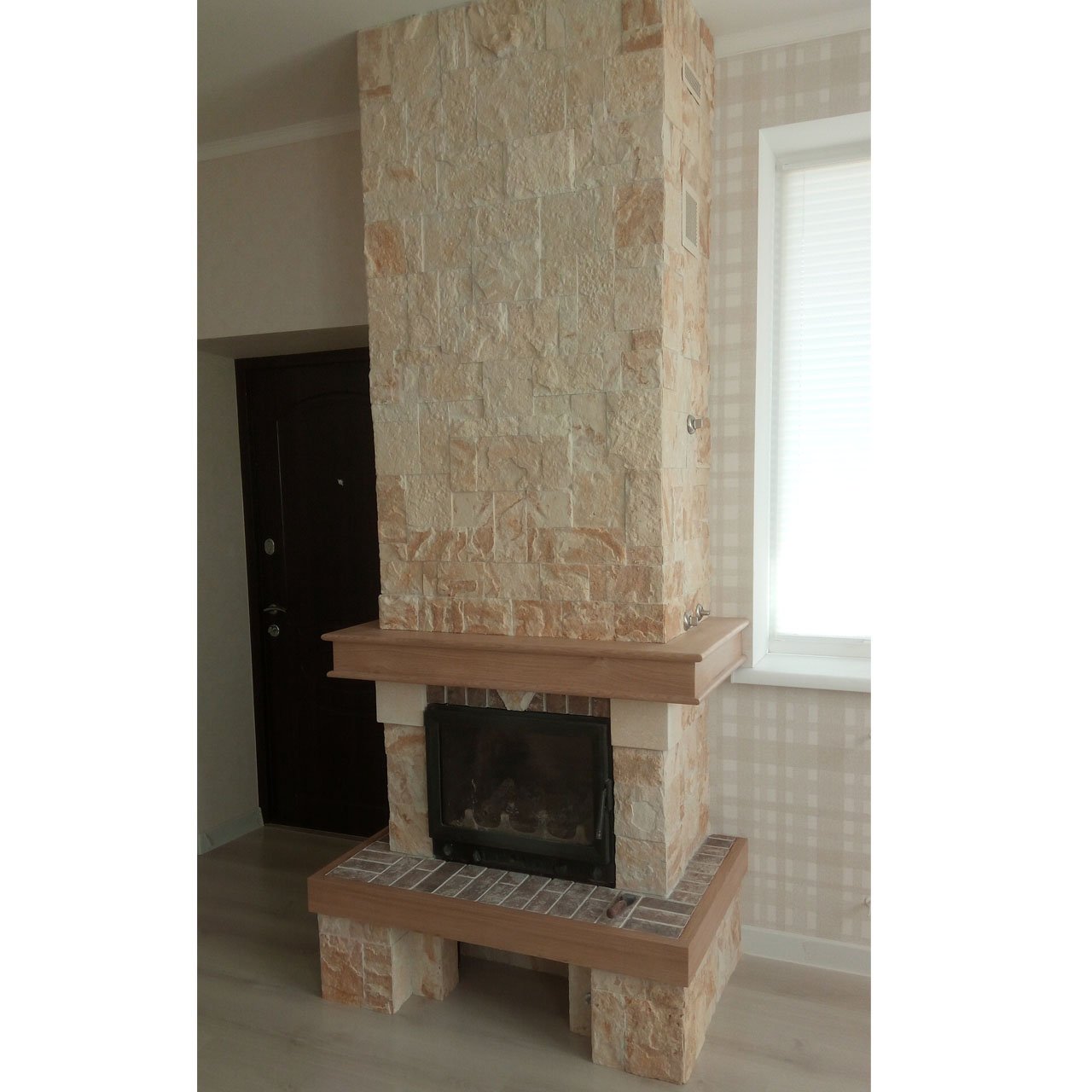 Kominek jest wyłożony kamieniem naturalnym, drewnem i płytkami ceramicznymi.