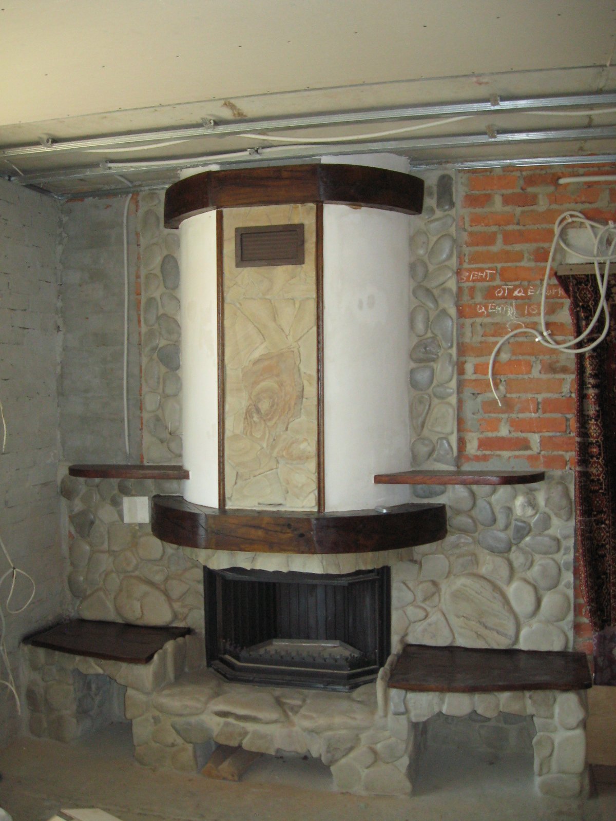 Kominek jest wyłożony kamieniem naturalnym, drewnem i płytkami ceramicznymi.